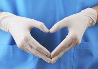 Doctors gloved hands forming a heart shape