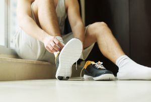Athlete in changing room puts his trainers on