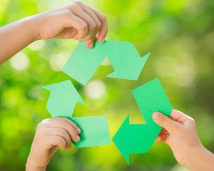Children's hands holding recycling icon