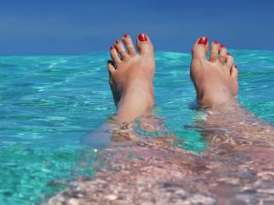Woman's feet sticking up from blue water