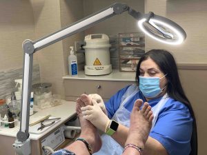 Podiatrist working on soles of patient's feet