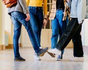 Group of young people touching toes with each other their shoes on as a greeting